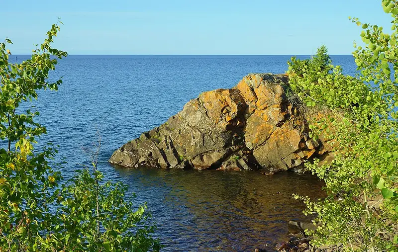 Rocky outcrop in Lake Superior framed by trees